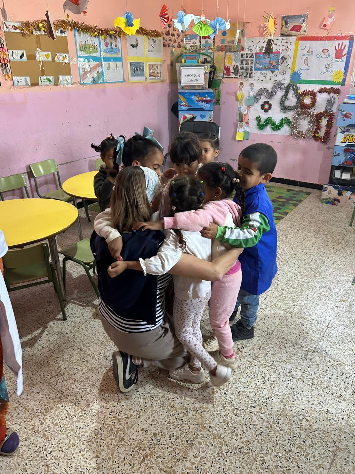 Integrante del equipo visitante compartiendo un momento con niños y niñas en el aula